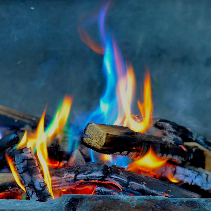 Close-up of burning wood with flames and embers on a dark background