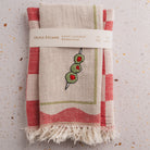 Hand-loomed kitchen towel with embroidery on a textured surface