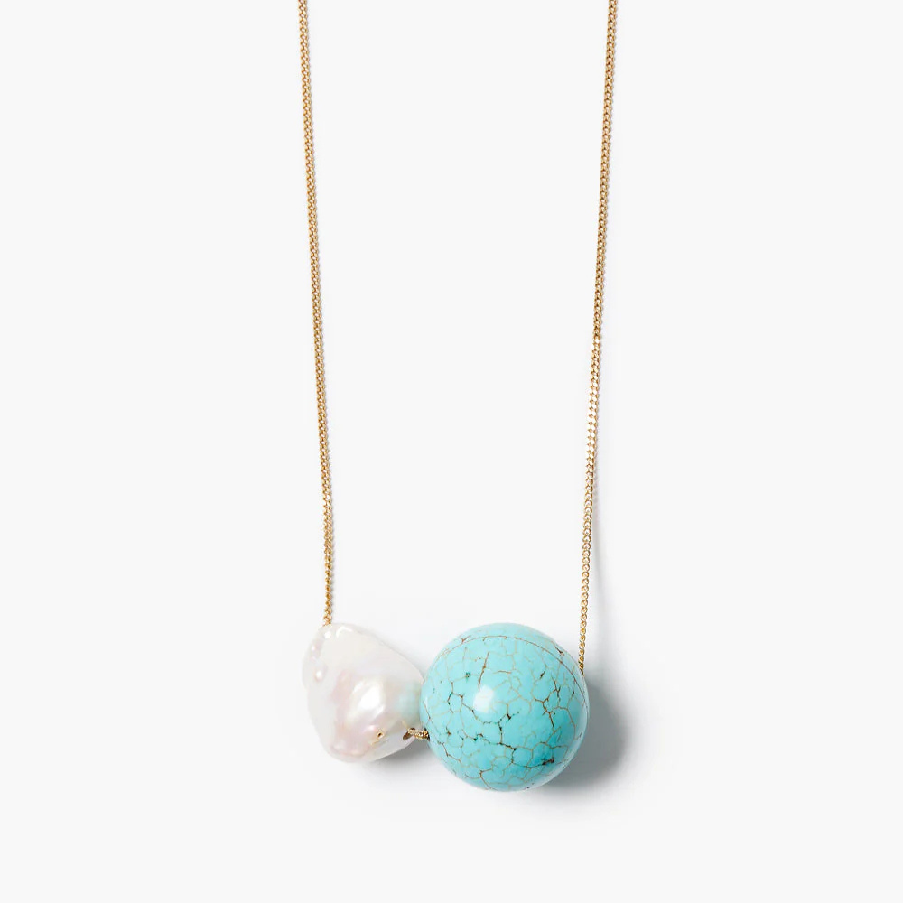 Necklace with a turquoise bead and pearl on a white background
