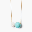 Necklace with a turquoise bead and pearl on a white background