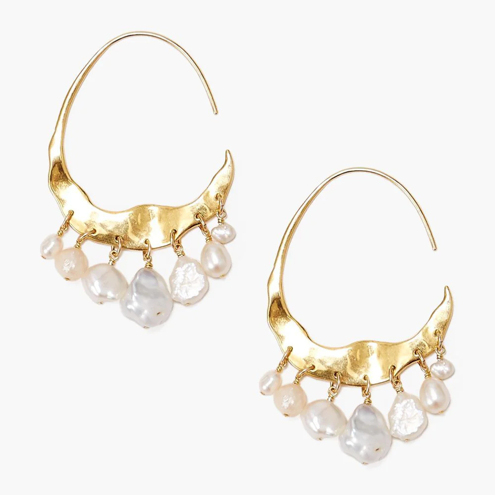 Gold hoop earrings with pearl drops on a white background