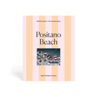 Pacifica Puzzle Co. Positano Beach puzzle packaging with striped design and photo of beach scene.