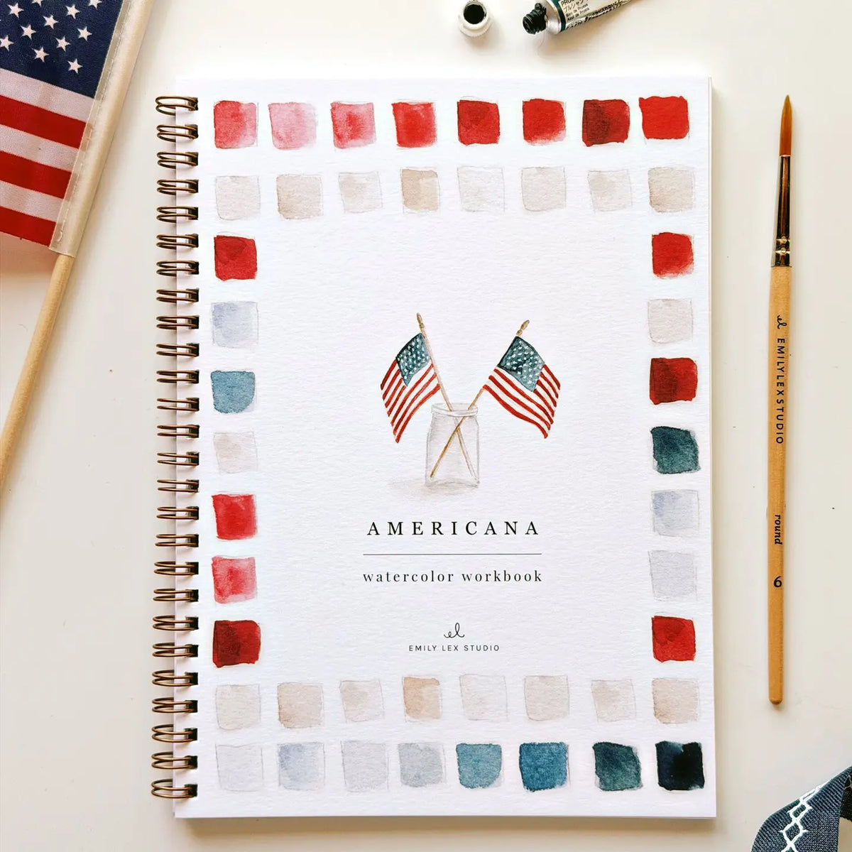 Watercolor workbook titled 'Americana' with American flags and color swatches on a white background.