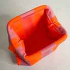 Red and orange checkered fabric basket on a light gray background