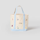 Tote bag with colorful designs and text on a light gray background