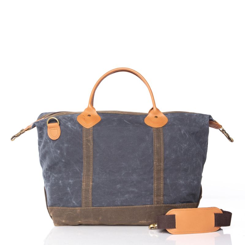 Blue waxed canvas bag with brown leather accents on a white background