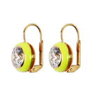 Gold earrings with neon green circular stones and clear crystals on a beige background