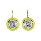Pair of earrings with clear gemstones and yellow circular accents on a light beige background