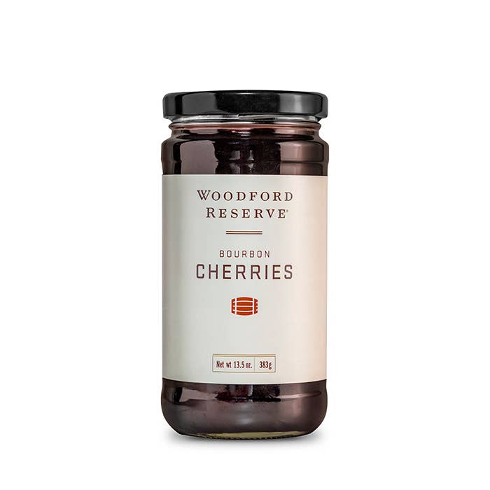 A jar of Woodford Reserve Bourbon Cherries with a white label, black text, and the brand's logo.