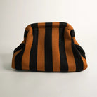 Striped bag with black and orange horizontal stripes on a light gray background