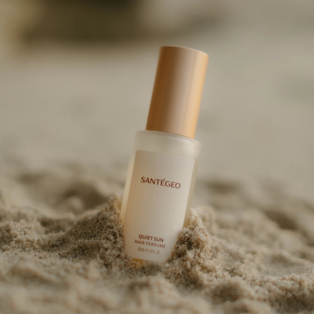 Santégéo perfume bottle on sand with blurred background