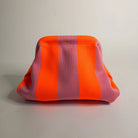Pink and orange striped pouch on a light gray background