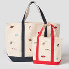 Two tote bags with embroidered designs on a light gray background