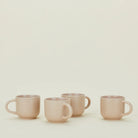 Four pink mugs on a light beige background