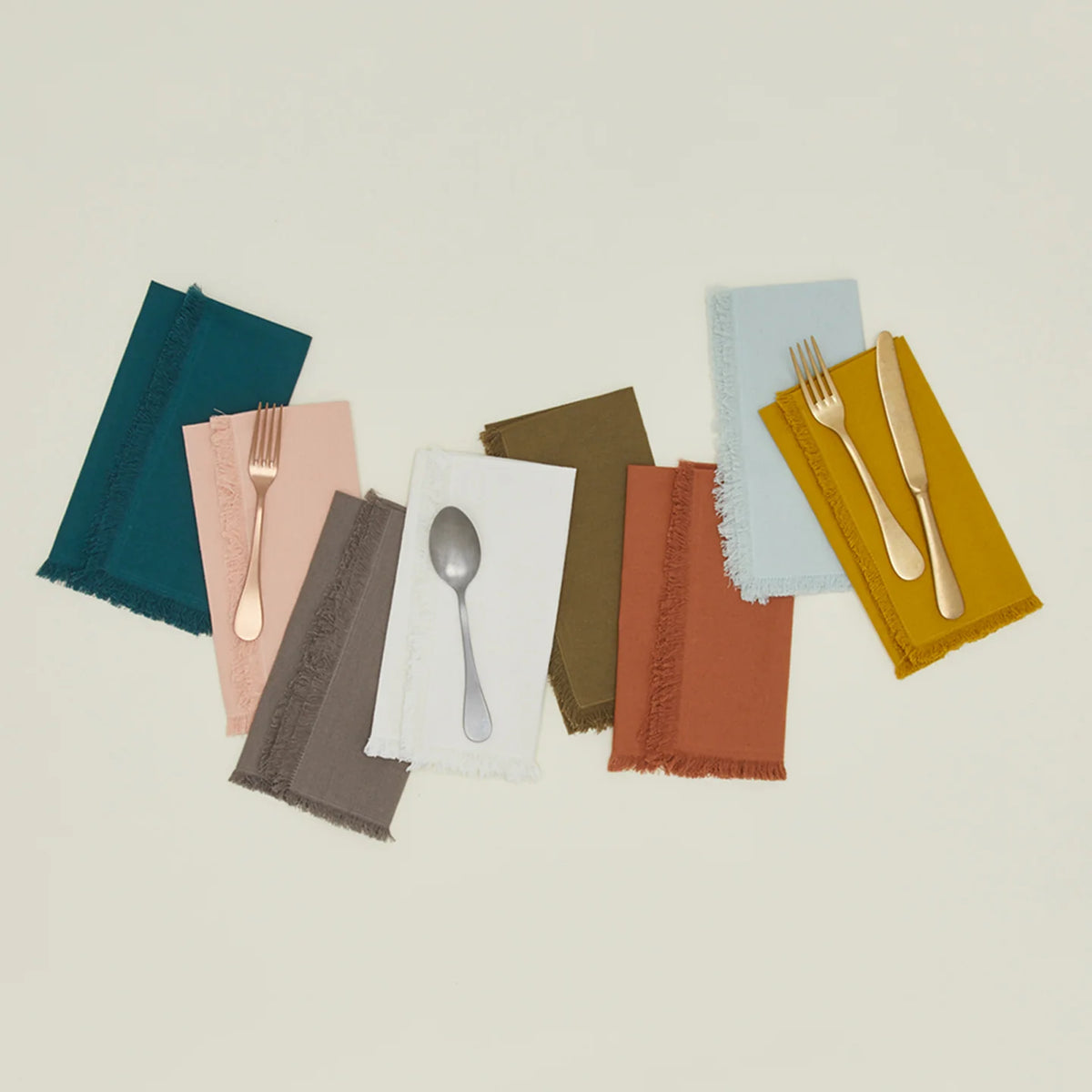 Set of colorful napkins with cutlery on a light background
