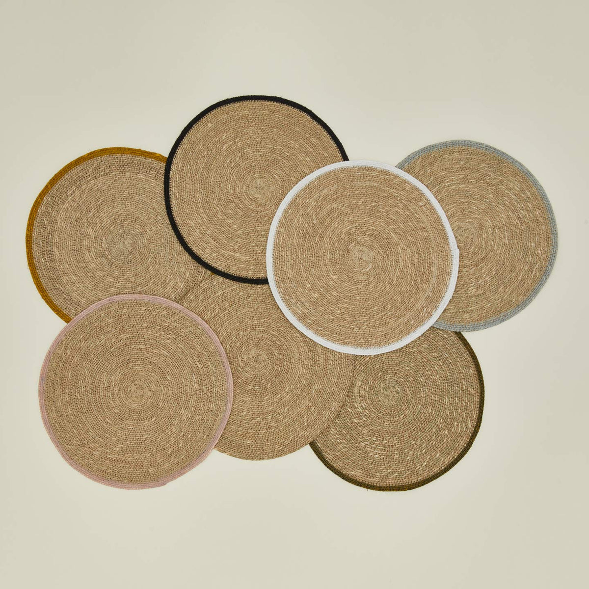 Set of round woven coasters on a beige background