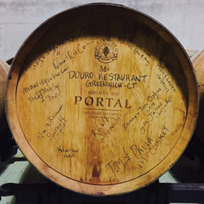 Guests of the tour signed a barrel of red wine that will be bottled and delivered to Douro restaurant. Left, a winemaker offers up a taste