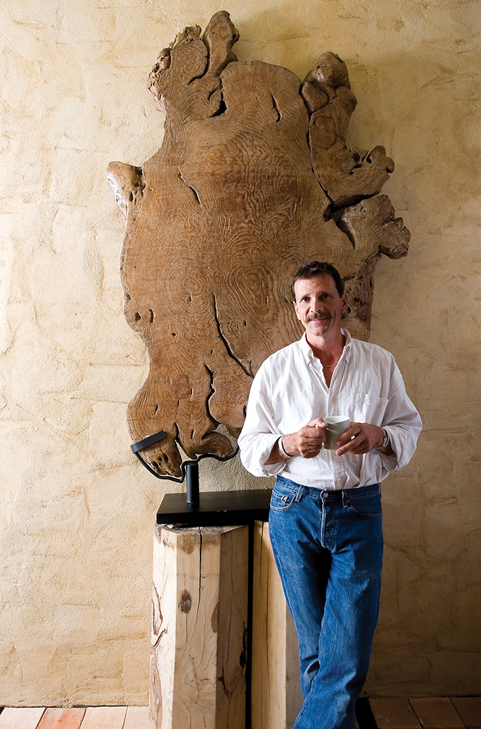 Michael Trapp poses with a cross-section of ancient petrified wood from a Buddhist temple.